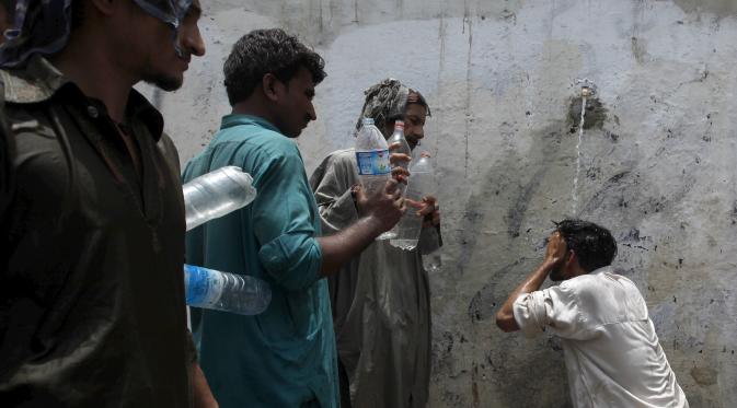 Sejumlah orang saat menunggu giliran untuk mengambil air saat cuaca panas yang ekstrem di Karachi, Pakistan, (23/6/2015). Gelombang panas yang telah menewaskan lebih dari 400 jiwa di kota selatan Pakistan. (REUTERS/Akhtar Soomro)