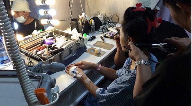 Andien tengah bersiap-siap sebelum manggung, meski jarum infus masih menancap di tangannya.