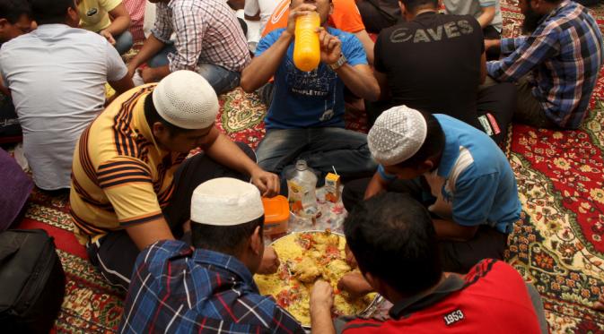  Muslim memiliki makanan berbuka puasa selama bulan suci Ramadan di luar sebuah masjid di Doha, Qatar, dengan kurma