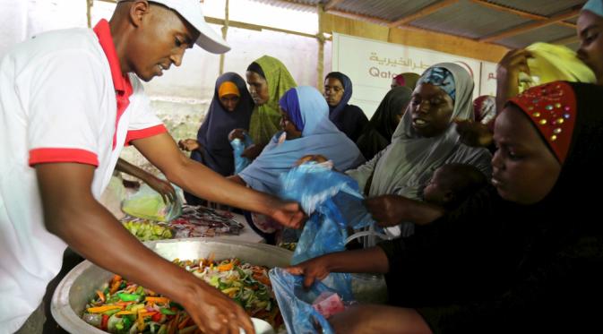  Keluarga Somalia menerima Iftar makanan dari sebuah organisasi amal Qatar di ibukota Mogadishu,