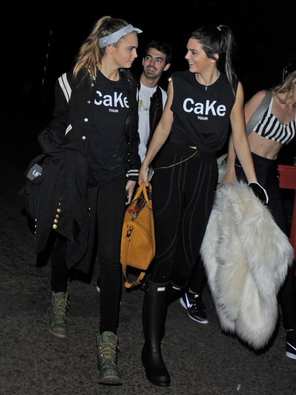 Kendall Jenner dan Cara Delevingne kompak memakai t-shirt yang sama bertuliskan 'CaKe TOUR'.(via splash news)