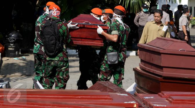 Sejumlah petugas menggotong peti mati di RSUP Haji Adam Malik, Medan, Sumatera utara, Kamis (2/7/2015). Setelah menjalani pemeriksaan dan teridentifikasi, jenazah korban Hercules C-130 akan dipulangkan ke keluarga korban. (Liputan6.com/Johan Tallo)