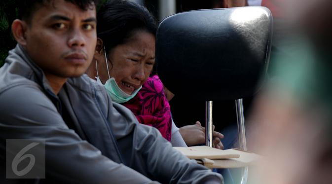 Keluarga korban jatuhnya pesawat Hercules C-130 menangis saat menunggu di halaman RSUP Haji Adam Malik, Medan, Sumatera utara, Kamis (2/7/2015). Mereka cemas menanti kepastian kabar anggota keluarganya dari tim DVI. (Liputan6.com/Johan Tallo)