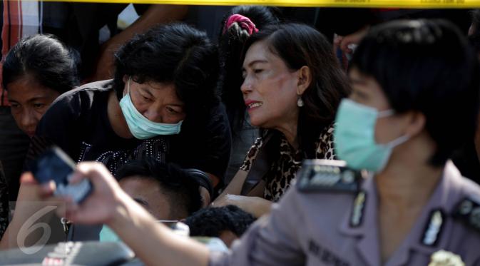 Keluarga korban jatuhnya pesawat Hercules C-130 ketika menunggu di halaman RSUP Haji Adam Malik, Medan, Sumatera utara, Kamis (2/7/2015). Mereka cemas menanti kepastian kabar anggota keluarganya dari tim DVI. (/Johan Tallo)