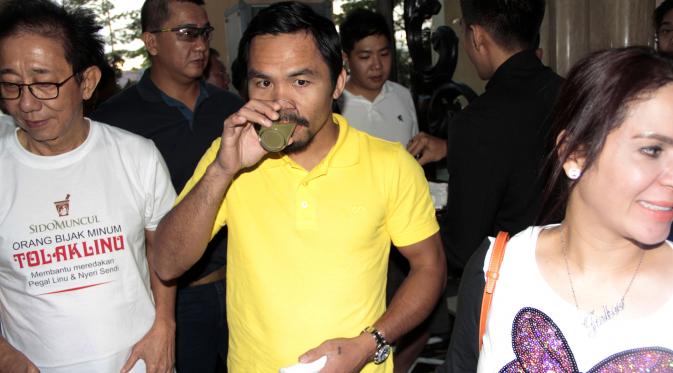 Manny Pacquiao tengah menikmati jamu tradisional Indonesia yang berguna menyembuhkan penyakit masuk angin.(Bola.com/Vincensius Sawarno)