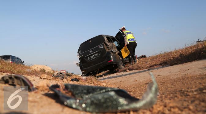 Petugas kepolisian memeriksa kendaraan yang mengalami kecelakaan di Tol Cipali, Jawa Barat, Senin (13/7/2015). Mobil bernomor polisi D 1807 PB tersebut menabrak penanda jalan di Km 149+800. (Liputan6.com/Herman Zakharia)