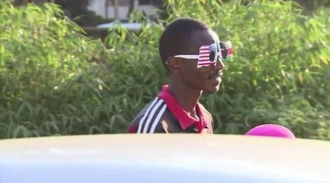 Pria di Nairobi berjalan memakai kaca mata bendera AS. Ia tampak semangat menyambut kedatangan Obama. (ABCnews)