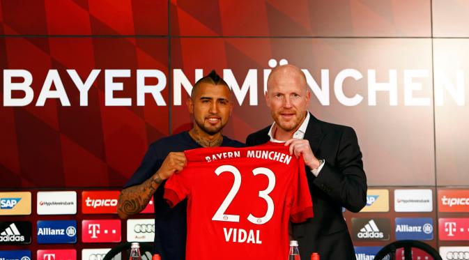 Gelandang Chile, Arturo Vidal bersama Matthias Sammer berpose dengan jersey Bayern Muenchen di Allianz Arena, Muenchen, Jerman (28/7/2015). Bayern Muenchen resmi mengontrak Vidal dengan kontrak selama empat musim. (REUTERS/Michaela REHL)