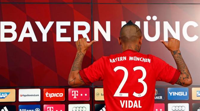 Arturo Vidal memperlihatkan nomor punggung yang akan di pakai di klub barunya usai resmi bergabung di Allianz Arena, Jerman (28/7/2015). Vidal dibeli Bayern dari Juventus dengan harga 40 juta euro atau setara Rp 593 miliar. (REUTERS/Michaela REHL)