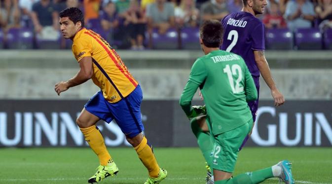 Striker Barcelona Luis Suarez menjebol gawang Fiorentina yang dijaga kiper Ciprian Tatarusanu dalam ajang International Champions Cup (ICC) 2015, Senin (3/8/2015). (TIZIANA FABI / AFP)