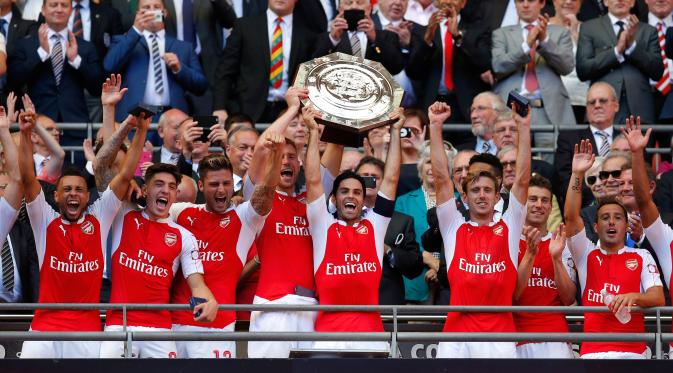 Gelandang Arsenal, Mikel Arteta bersama pemain lainnya mengangkat trofi usai memenangkan gelar FA Community Shield di Wembley Stadium, Minggu (2/8/2015). Arsenal menang atas Chelsea dengan skor 1-0. (Reuters/Andrew Couldridge)