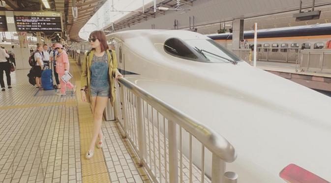 Vicky Shu berpose disamping kereta Shinkansen, kereta super cepat di Jepang. (Instagram @vickyshu)