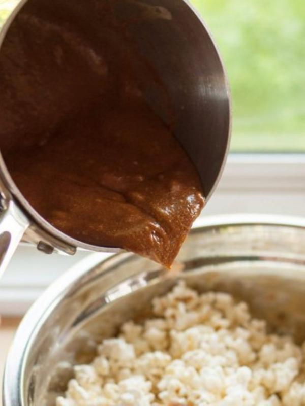 Tuang saus karamel perlahan di atas popcorn sambil diaduk.(Via: thekitchn.com)