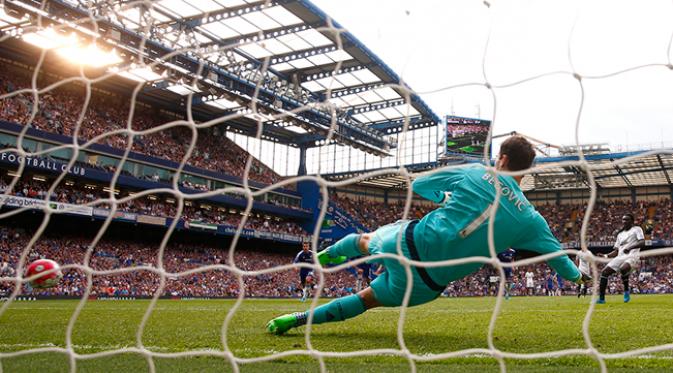 Penyerang Swansea, Bafetimbi Gomis mengeksekusi penalti ke gawang Chelsea yang dijaga Asmir Begovic pada laga Liga Premier Inggris di Stadion Stamford Bridge, Inggris, Sabtu (8/8/2015). Pertandingan berakhir imbang 2-2. (Reuters/Eddie Keogh)