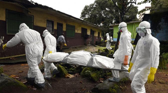 Petugas medis dari Croix Rouge LSM membawa jenazah korban Ebola dari sebuah rumah di Monrovia, Liberia, 29 September 2014. Dari empat negara di Afrika Barat, Liberia menjadi negara yang paling parah terkena wabah Ebola. (AFP PHOTO/PASCAL GUYOT)