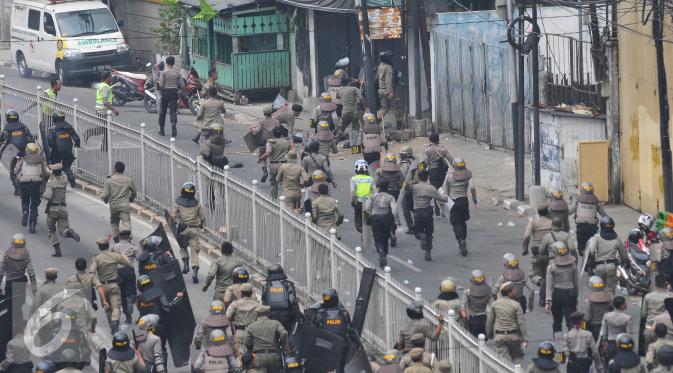 Petugas kepolisian dan Satpol PP saat menertibkan lokasi penggusuran Kampung Pulo, Jakarta, Kamis (20/8/2015). Penggusuran pemukiman Kampung Pulo dilakukan oleh 2.200 personel gabungan untuk normalisasi Sungai Ciliwung. (Liputan6.com/Herman Zakharia)