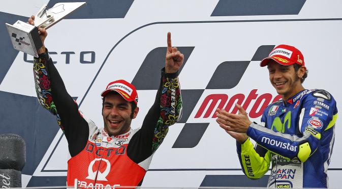 Pembalap dari Pramac Rancing, Danilo Petrucci (kiri) saat mengangkat piala juara kedua pada balapan Moto Gp seri ke-12 di sirkuit Silverstone (30/8/2015). Valentino Rossi finis pertama di seri ke-12 ini. (REUTERS/Darren Staples)