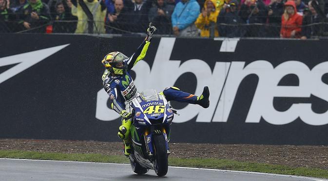 Pembalap Yamaha, Valentino Rossi melakukan selebrasi setelah berhasil finis pertama pada balapan MotoGP seri ke-12 di Sirkuit Silverstone (30/8/2015). Posisi kedua dan ketiga diduduki Danilo Petrucci dan  Andrea Dovizioso. (Reuters/Darren Staples)