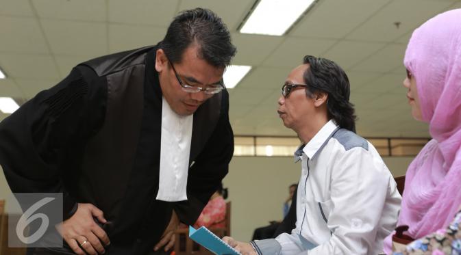Mandra Naih (kanan) saat berbincang dengan kuasa hukumnya sebelum  menjalani sidang lanjutan di Pengadilan Tipikor, Jakarta, Senin (31/8/2015). Sidang ini beragendakan pembacaan eksepsi atau nota keberatan dari terdakwa. (Liputan6.com/Herman Zakharia)