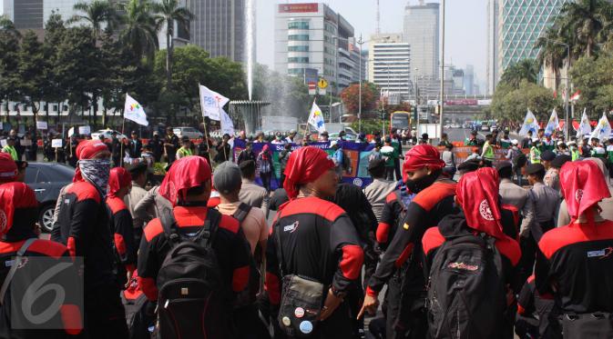 Ratusan buruh tampak berkumpul di sekitar kawasan Patung Kuda, Jakarta, Selasa (1/8/2015). Mereka menuntut pemerintah menghentikan gelombang PHK yang mengancam akibat melemahnya nilai tukar rupiah terhadap dolar. (Liputan6.com/Gempur M Surya)