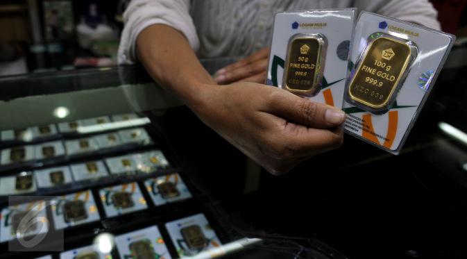 Pedagang menunjukan emas batangan 50 gram dan 100 gram di sebuah toko Kawasan Cikini, Jakarta, Kamis (3/9/2015). Harga emas milik PT Aneka Tambang Tbk (Antam) hari ini terpantau bergerak stabil di posisi Rp560 ribu per gram. (Liputan6.com/Johan Tallo)
