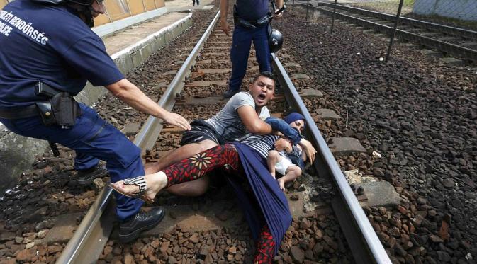 Seorang pria melemparkan anak dan bayinya ke rel di stasiun Kaleti, Budapest. 