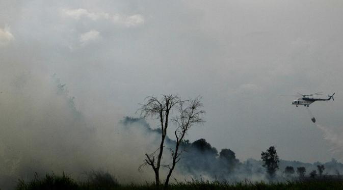 Sebuah helikopter melakukan pemadaman api di kawasan hutan di Ogan Ilir, Sumatera Selatan  (1/8/2015). (AFP PHOTO/ABDUL Qodir)