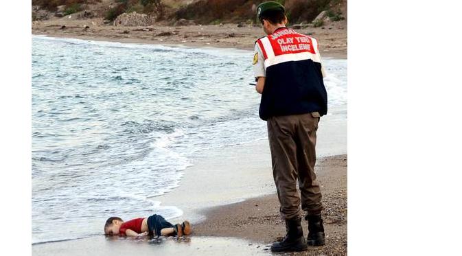 Petugas menemukan tubuh tak bernyawa Aylan Kurdi di tepi pantai. | via: independent.co.uk
