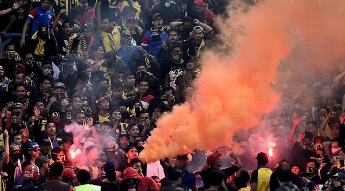 Suporter Malaysia menyalakan flare dan kembang api