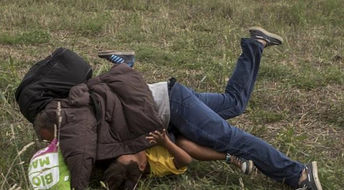 Pengungsi Suriah jatuh menindih anaknya setelah ditendang jurnalis Hungaria | Via: dailymail.co.uk