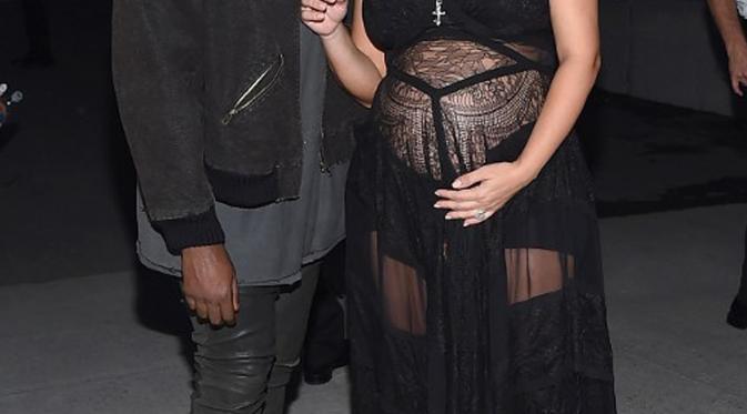 Kim Kardashian bersama suaminya, Kanye West tampak berbincang saat menghadiri Givenchy Spring/Summer 2016 pada acara New York Fashion Week di New York, Jumat (11/9/2015). (Michael Loccisano/Getty Images/AFP)