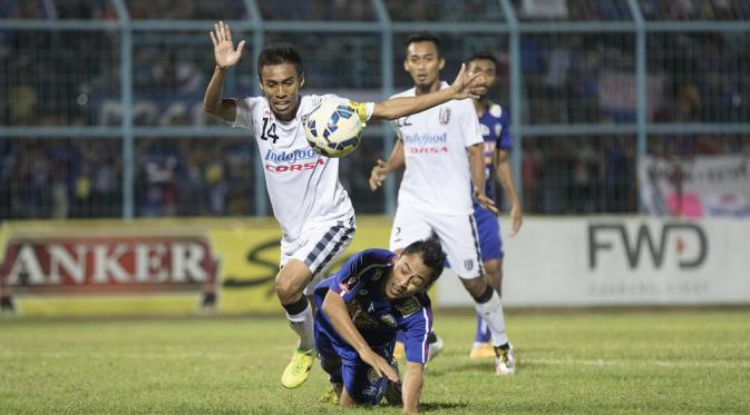 Kapten Bali United Pusam, Fadil Sausu berebut bola dengan striker Arema Cronus, Samsul Arif pada leg pertama babak 8 besar Piala Presiden di Stadion Kanjuruhan, Malang, Sabtu (19/9/2015). (Bola.com/Vitalis Yogi Trisna)