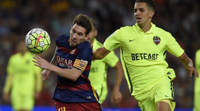 Penyerang Barcelona, Lionel Messi (kiri) berusaha mengejar bola dari kejaran bek Levante, Zou Feddal Pada lanjutan Liga Spanyol di stadion Camp Nou, Senin (21/9/2015). Barcelona menang telak atas Levante dengan skor 4-1. (AFP PHOTO/Lluis GENE)