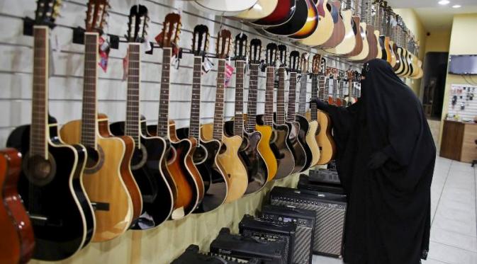 Gisele Marie sedang memilih gitar di sebuah toko | Via: dawn.com