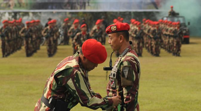 Danjen Kopassus Mayjen TNI M Herindra (kiri) menyarungkan pisau komando ke KSAD Jenderal TNI Mulyono pada Penyematan Brevet Komando di Makopassus, Jakarta, Jumat (25/9/2015). Mulyono mendapat tiga brevet kehormatan. (Liputan6.com/Helmi Fithriansyah)